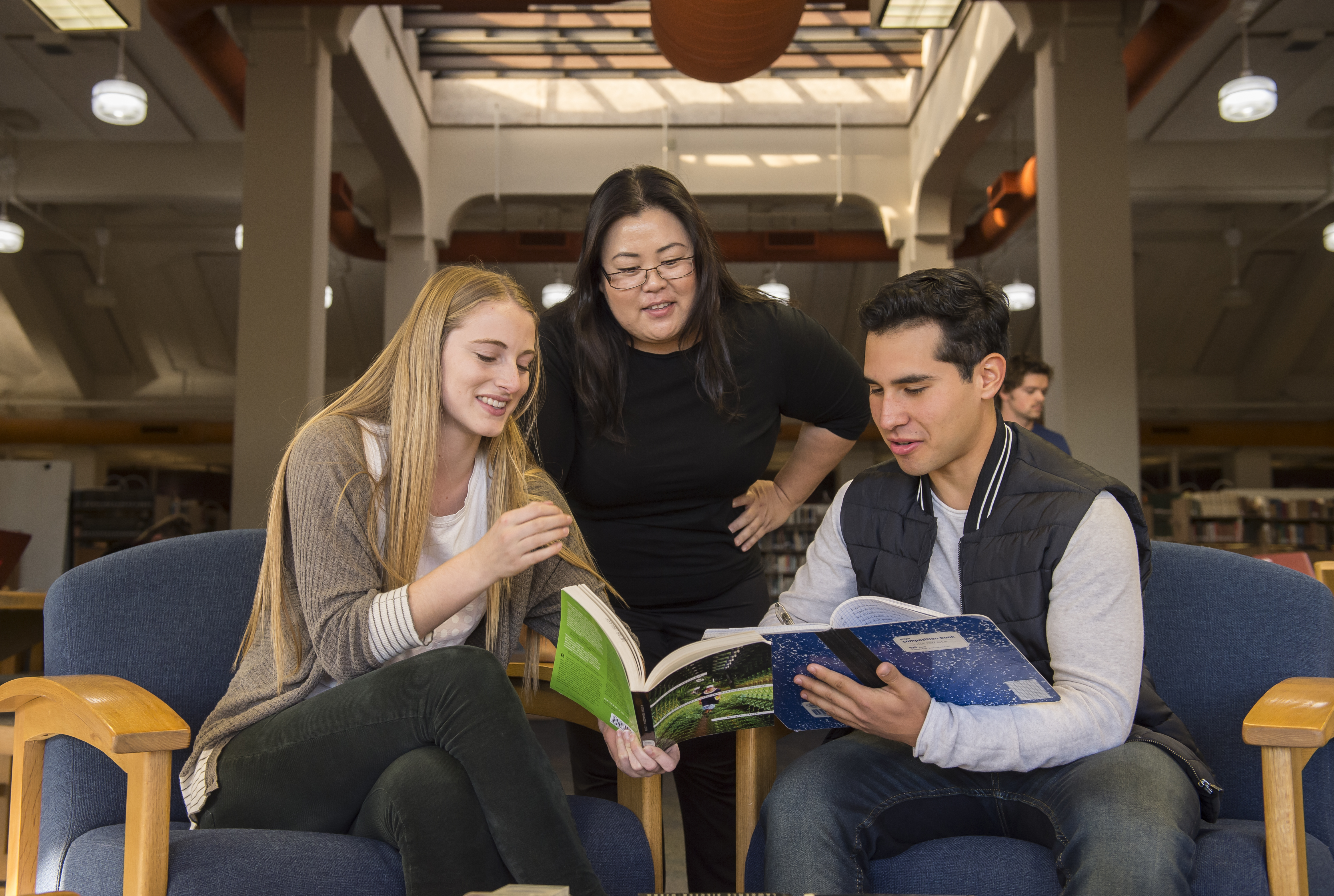 pre-college students talking to program director Lina Kim in library