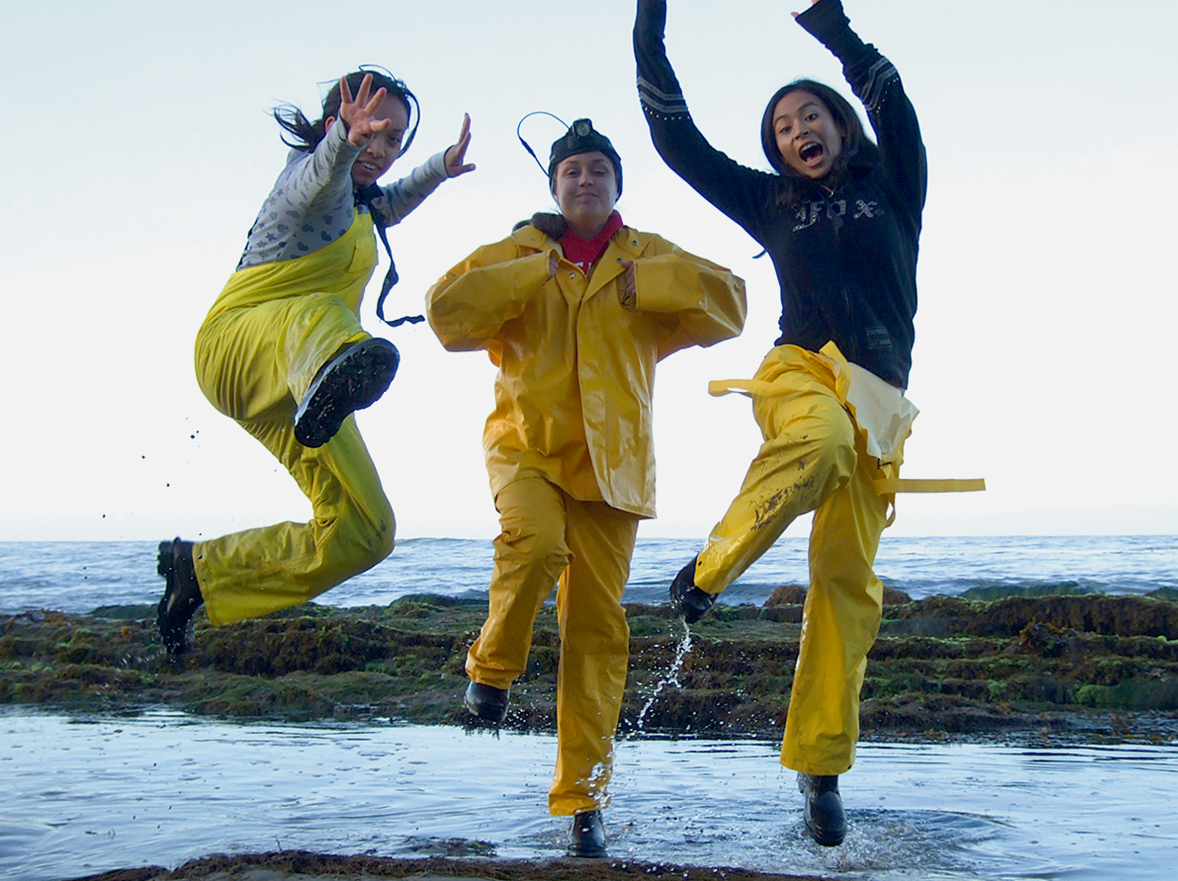 pre-college students jumping at beach