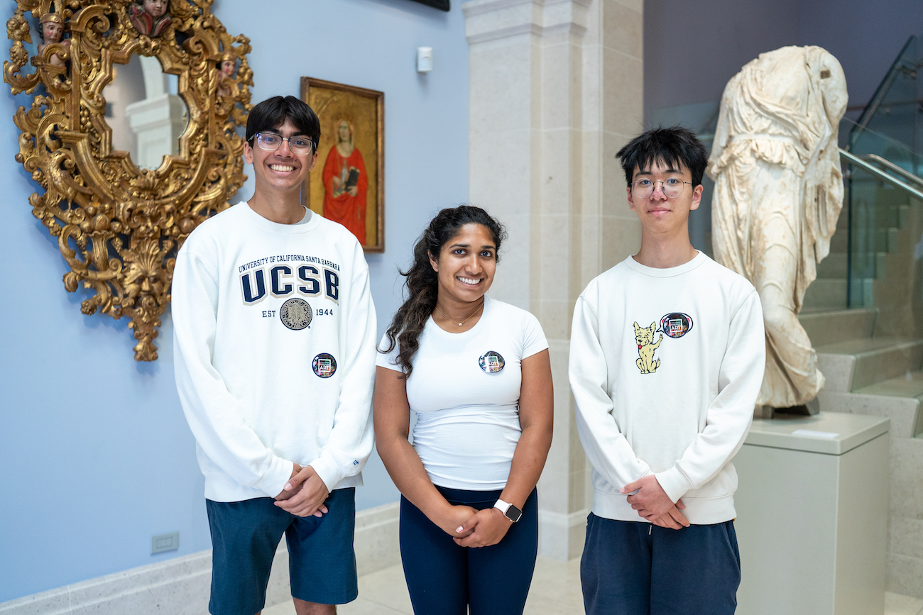 Three SRA students standing next to each other and posing for track photo