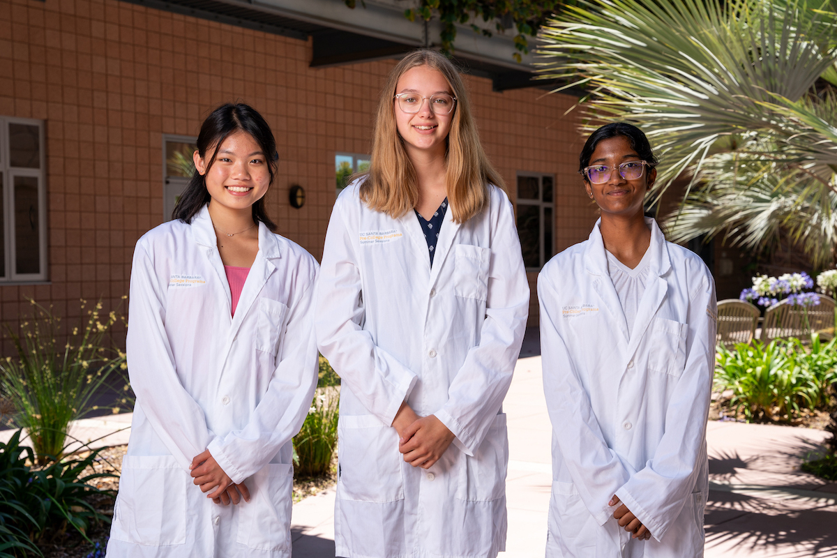 three SRA students posing for a group photo in lab coats