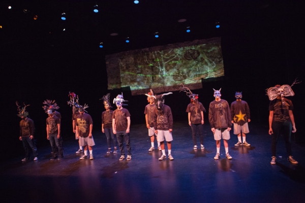 performers in masks on stage
