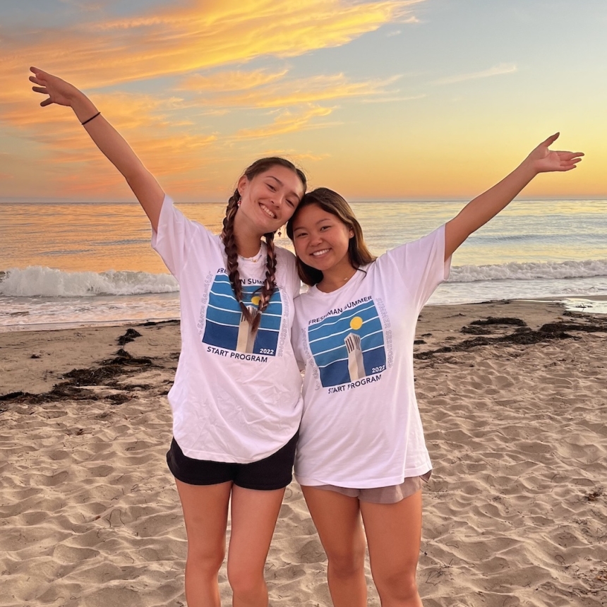 two students posing in front of the sunset at the beach, wearing FSSP program t-shirts